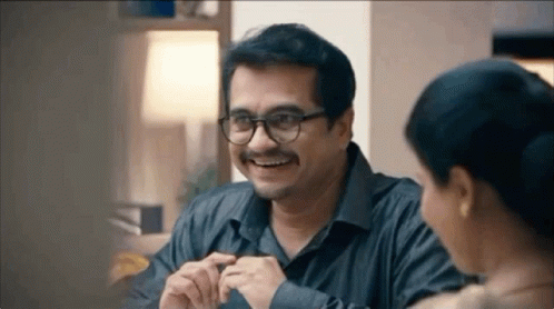 Smiling Man With Glasses and Mustache Talking to Woman