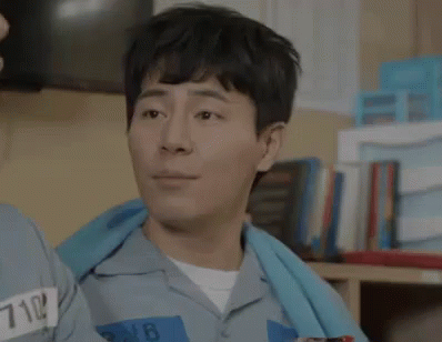 Smiling Prisoner Next To Another In Cell GIF