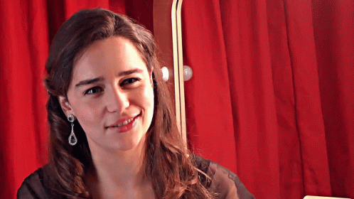 Smiling Woman with Earrings and Red Curtain