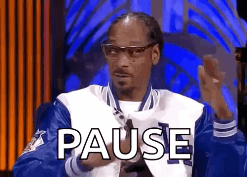 Snoop Dogg Is Wearing A Blue And White Jacket And Glasses While Sitting In Front Of A Blue Background . GIF