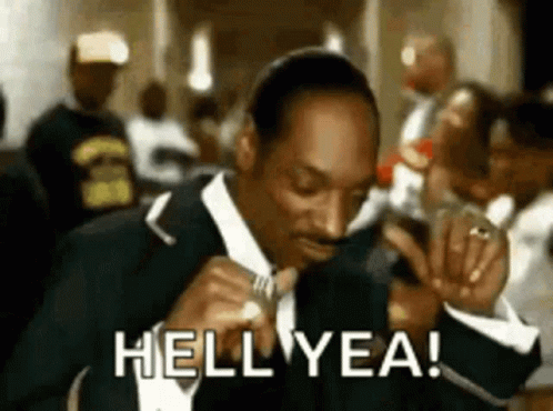 Snoop Dogg Is Wearing A Suit And Tie And Smoking A Cigarette While Saying Hell Yea . GIF