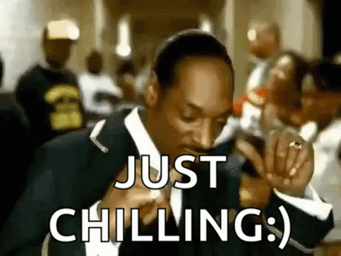 Snoop Dogg Is Wearing A Suit And Tie And Smoking A Cigarette While Saying `` Just Chilling '' . GIF