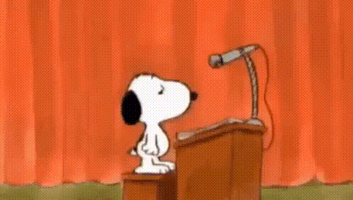 Snoopy Is Giving A Speech In Front Of A Microphone . GIF