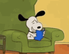 Snoopy Is Reading A Book While Sitting In A Green Chair . GIF