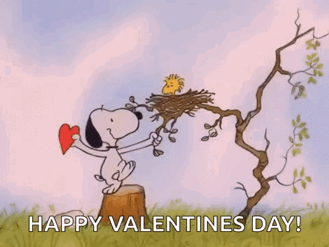Snoopy Is Standing On A Tree Stump Holding A Heart And Woodstock Is Sitting On A Nest . GIF