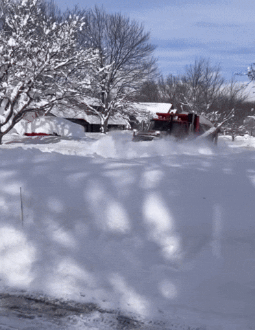 Snow Plow Driving Through Snowy Driveway