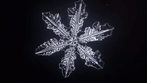 Snowflake Rotating In The Dark GIF