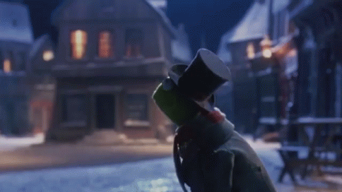 Snowman in Top Hat Standing in Snow in Front of Building