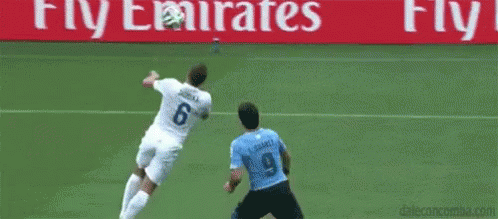 Soccer Goalie Jumping to Catch Ball While Player Blocks
