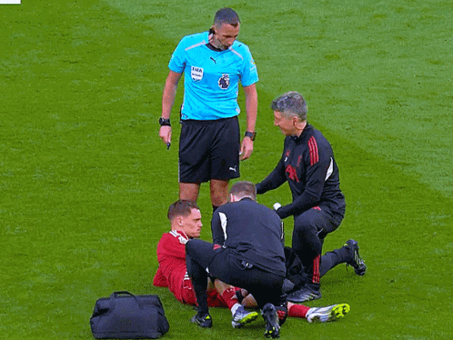 Soccer Player Helped by Referee in Puma Shirt