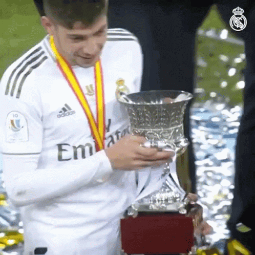 Soccer Player Holding Trophy in Emirates Shirt