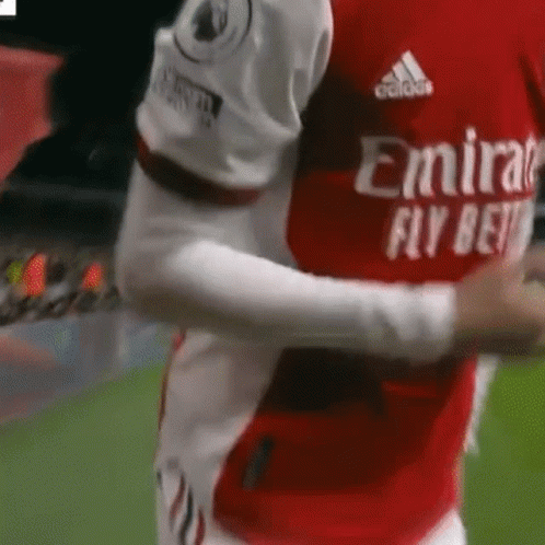 Soccer Player Hugging Teammate in Red and White Jersey