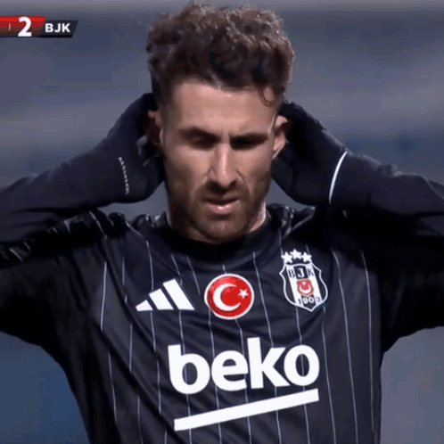 Soccer Player in Black Beko Jersey Holding Head