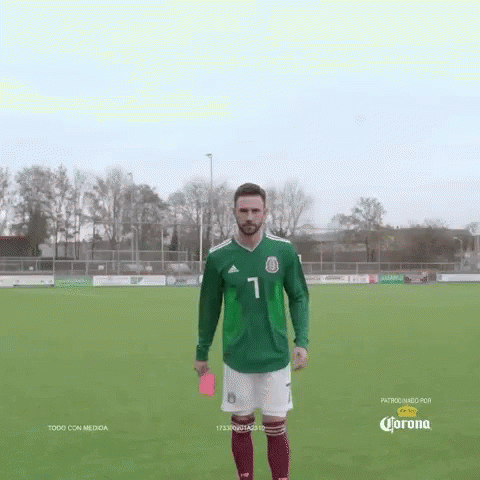 Soccer Player in Green Jersey Holds Red Card