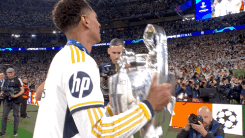 Soccer Player in HP Shirt Holding Trophy
