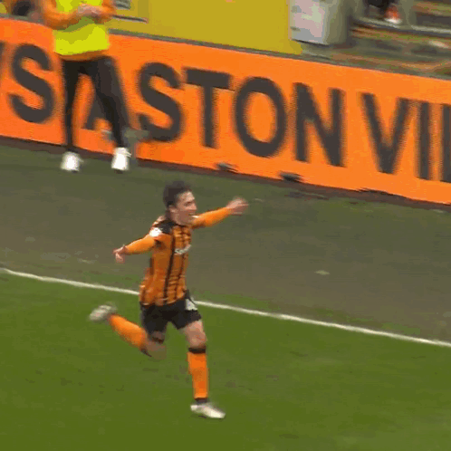 Soccer Player in Orange and Black Running