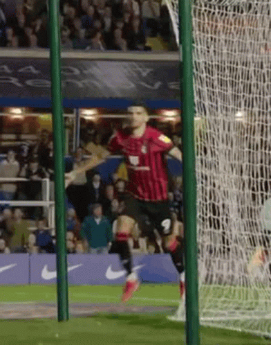 Soccer Player in Red and Black Celebrating Goal