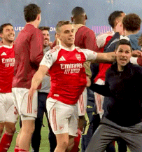 Soccer Player in Red Emirates Jersey Surrounded by Teammates