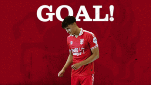 Soccer Player in Red Jersey at Goal Sign
