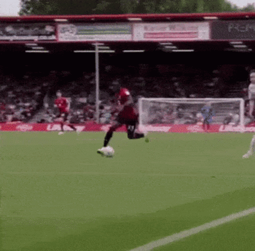 Soccer Player in Red Jersey Kicking Ball