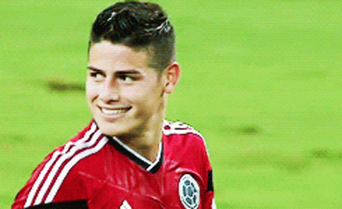 Soccer Player in Red Shirt Scratching Head on Field