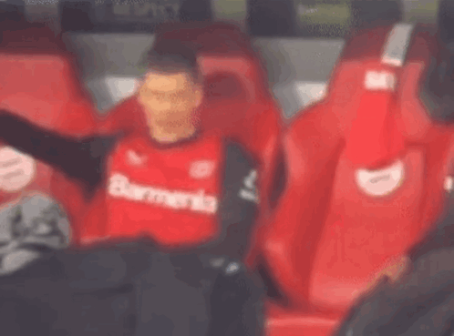 Soccer Player in Red Shirt Sitting in Stands