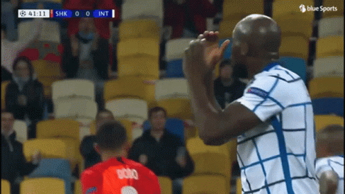 Soccer Player in White and Blue High Fiving Another