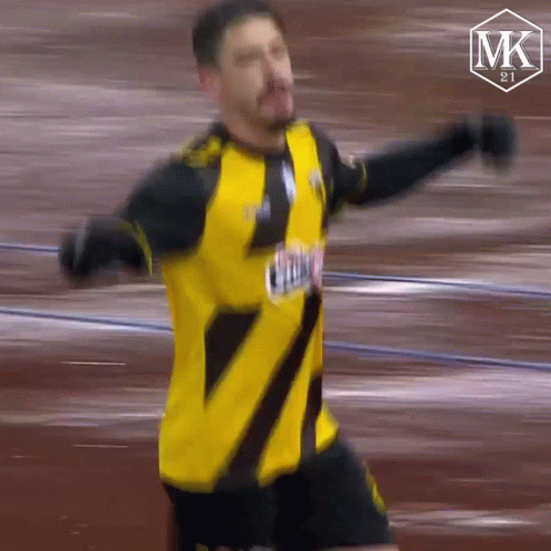 Soccer Player in Yellow and Black Jersey Saying MK