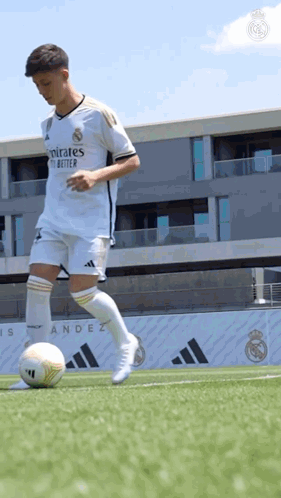 Soccer Player Kicking Ball on Field with Building