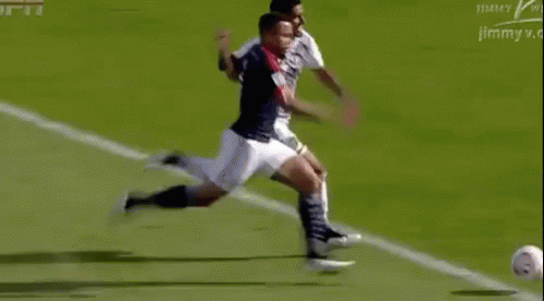 Soccer Player Kicking Ball Opponent Trying to Stop