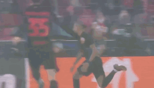 Soccer Player Kneeling in Front of Follow Sign