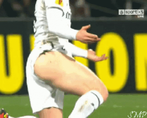 Soccer Player Kneeling in Front of Sport Sign