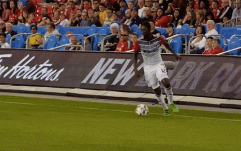 Soccer Player Number 12 Kicking Ball