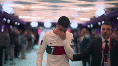 Soccer Player Number 7 Helped by Man in Suit