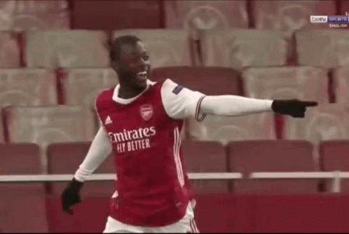 Soccer Player Pointing at Camera in Red Emirates Fly Better Shirt