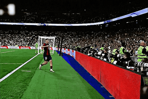 Soccer Player Running on Field With Emirates Ads