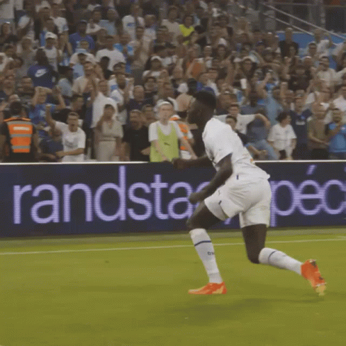 Soccer Player Running on Field with Randstad Spec Banner