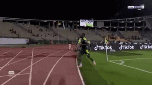 Soccer Player Running on Stadium Track