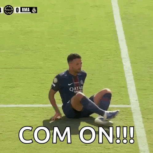 Soccer Player Sits on Field with Com On