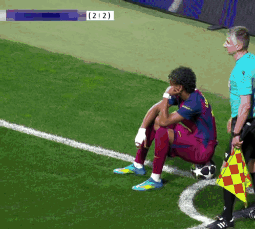 Soccer Player Sitting on Field with Number 212