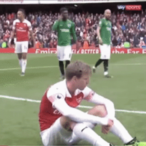 Soccer Player Sitting on Ground During Match