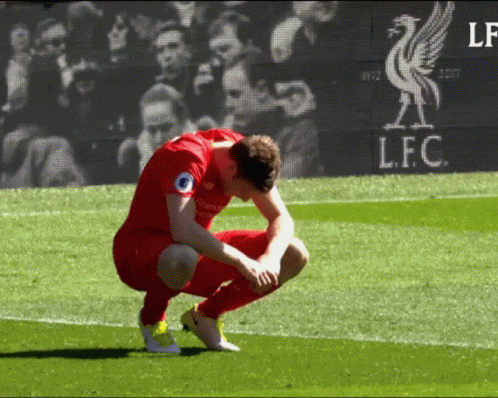 Soccer Player Squatting on Field by LFC Screen
