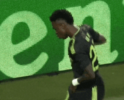 Soccer Player Standing In Front Of Green Sign GIF