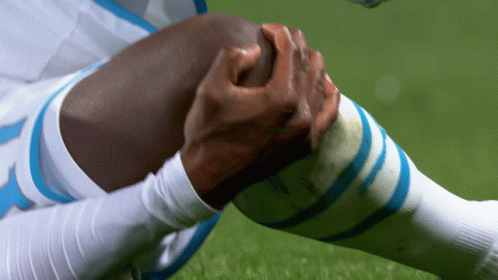 Soccer Player With Blue White Socks Holding Knee GIF