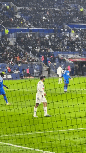 Soccer Players Behind Net With Crowd in Stands