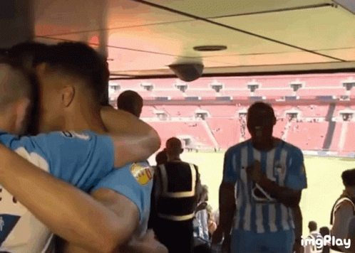 Soccer Players Hugging In Stadium GIF