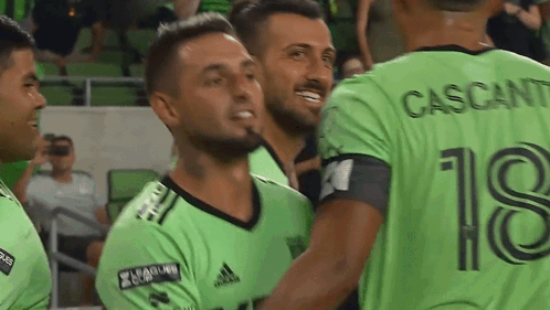 Soccer Players In Green Jersey Number 18 Hugging GIF