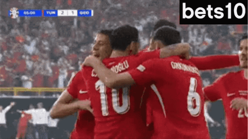 Soccer Players In Red Jerseys 10 And 6 Hugging GIF