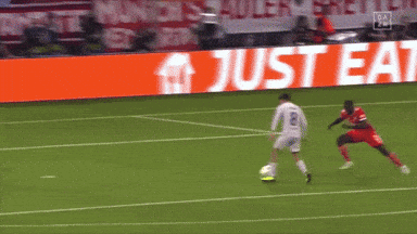 soccer players on a field in front of a just eat sign