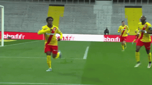 Soccer Players On A Field With A Banner That Says Auchan GIF